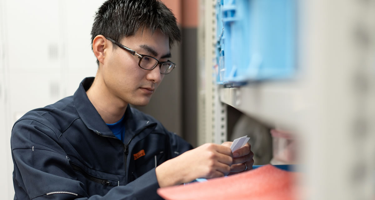 工場内で設備を点検する若手社員