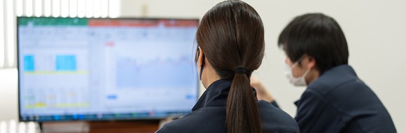 モニターを見ながら打ち合わせる社員